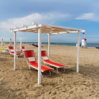 Area relax attrezzata sulla spiaggia di Marebello, perfetta per godersi il mare in tranquillità. Lettini relax sotto pergola sulla spiaggia di Marebello a Rimini